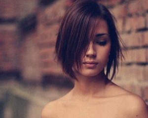 Photo of a girl near a brickwall